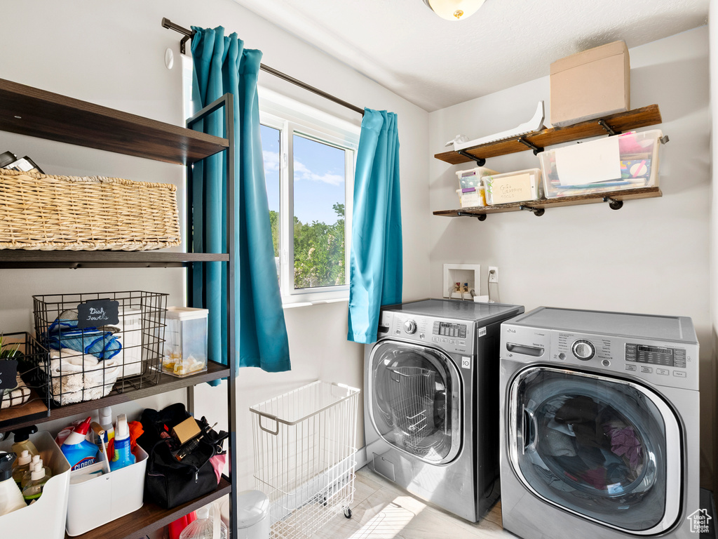 Washroom with washer and clothes dryer and tile patterned floors