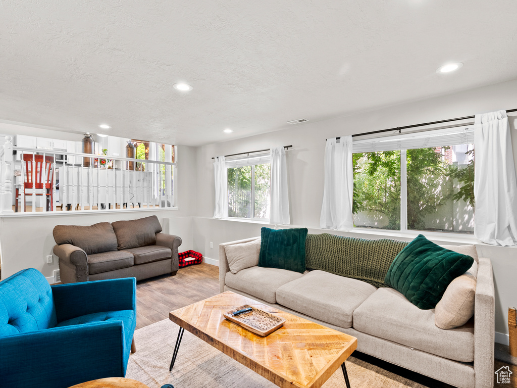 Living area with wood finished floors, recessed lighting, and baseboards