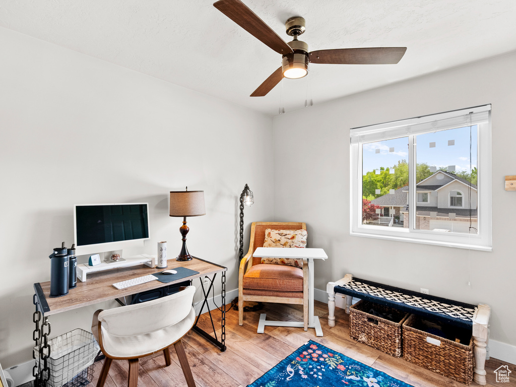 Home office featuring ceiling fan, wood finished floors, and baseboards