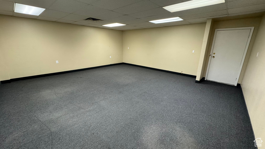 Empty room with a paneled ceiling and baseboards