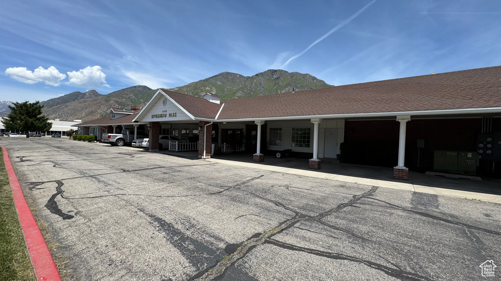 View of building exterior featuring a mountain view and covered parking