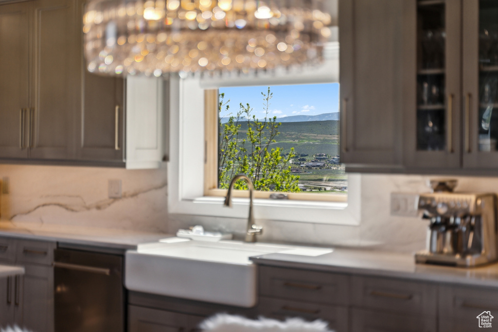 Kitchen featuring dishwasher, a mountain view, decorative backsplash, a sink, and light countertops