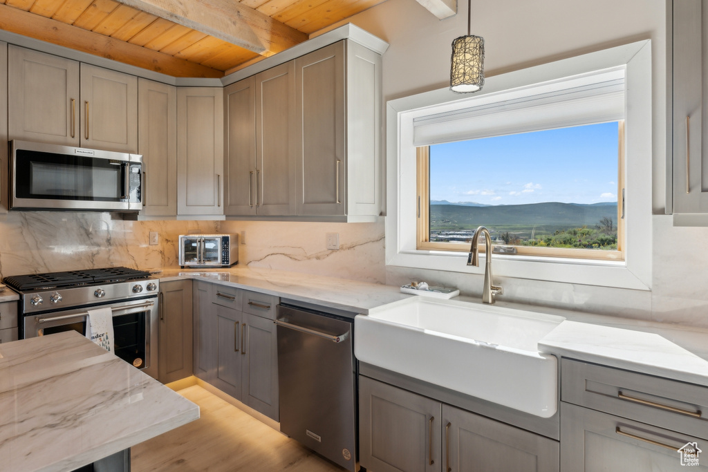 Kitchen featuring stainless steel appliances, wood ceiling with exposed beams, a sink, gray cabinets, and decorative backsplash