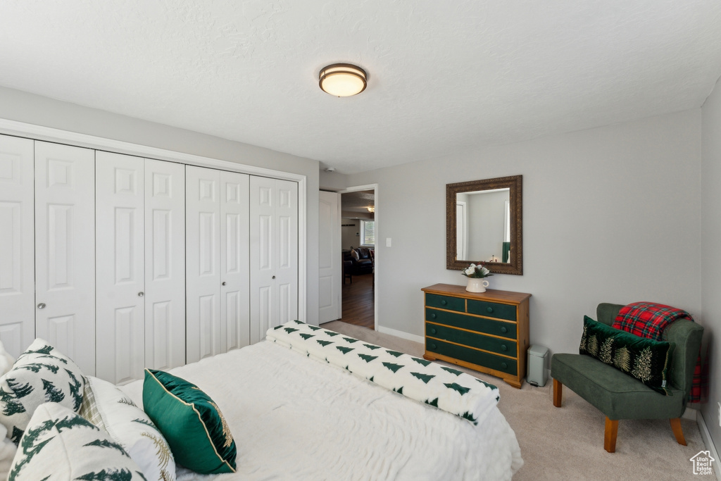 Carpeted bedroom featuring a closet and baseboards