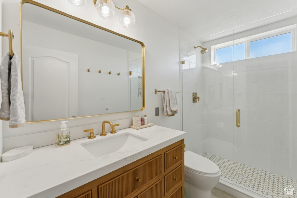Full bathroom featuring a stall shower, toilet, and vanity