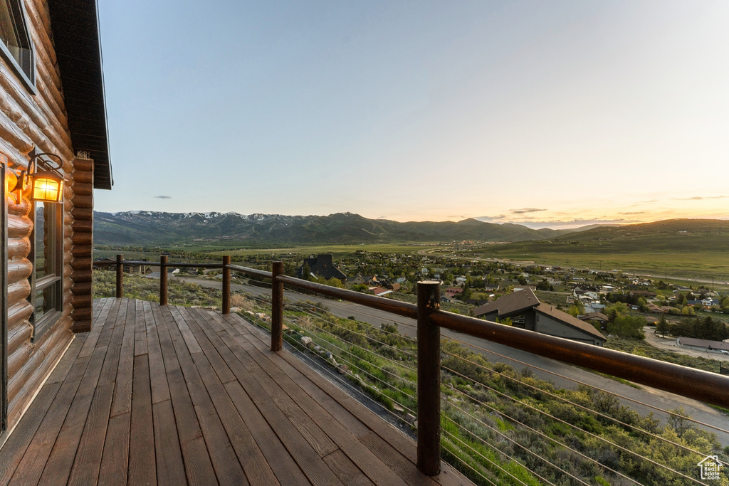 Deck at dusk featuring a mountain view