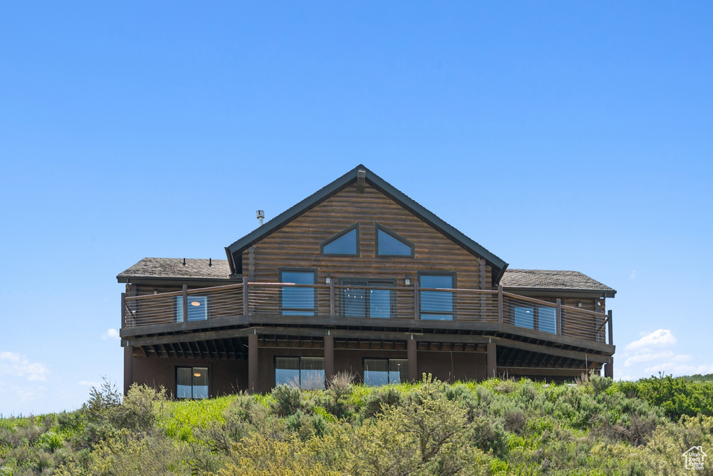 Rear view of house featuring log siding and a deck