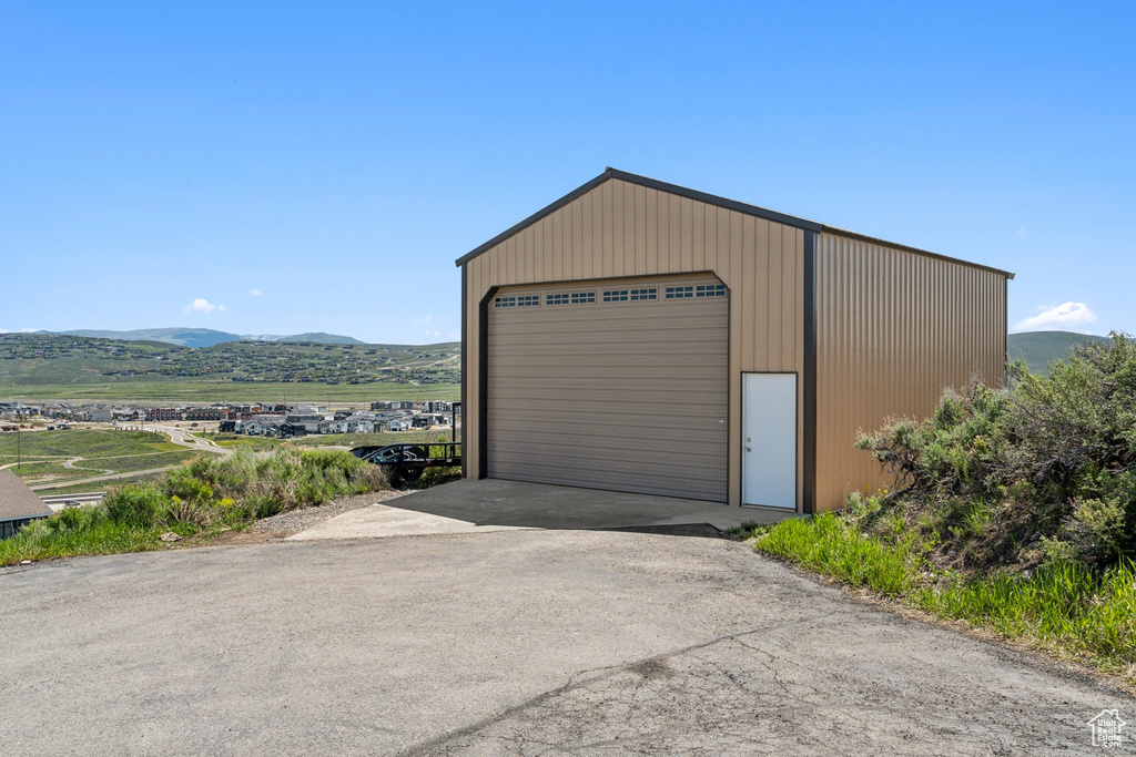 Detached garage featuring a mountain view and driveway