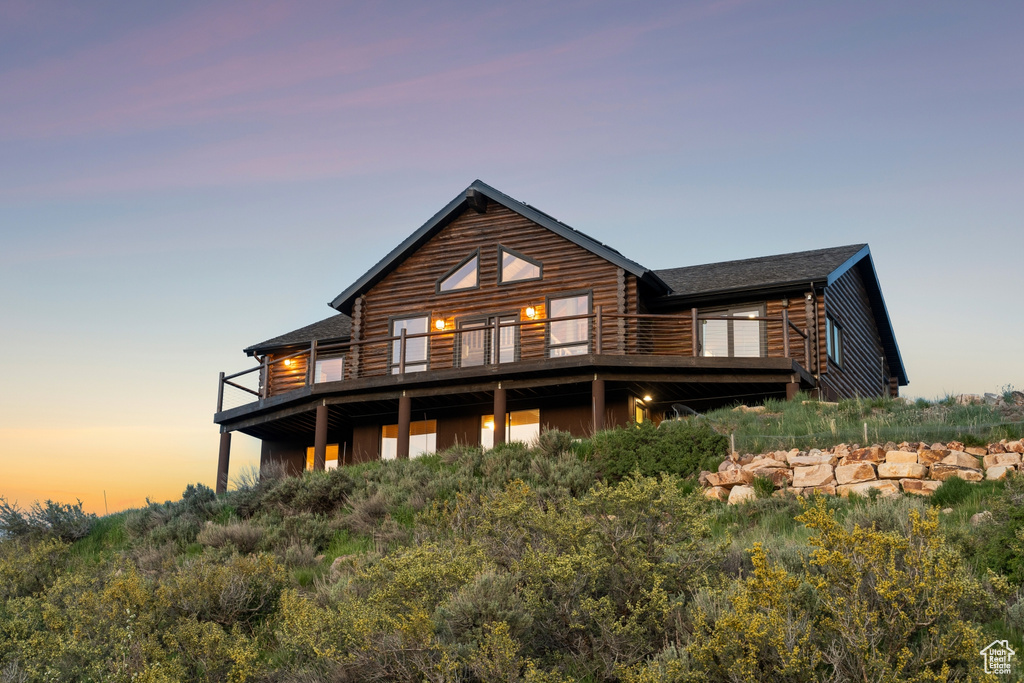 Back of property at dusk with a balcony