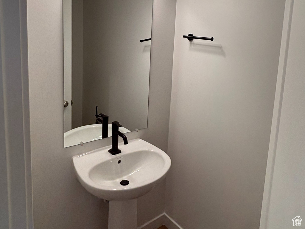 Bathroom with wood finished floors, baseboards, and a sink