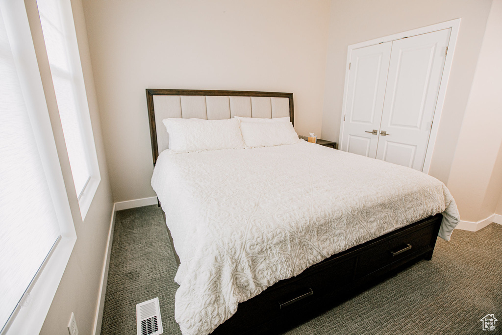 Carpeted bedroom featuring baseboards and a closet