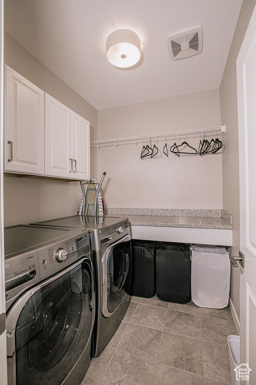 Washroom with cabinet space and washing machine and dryer