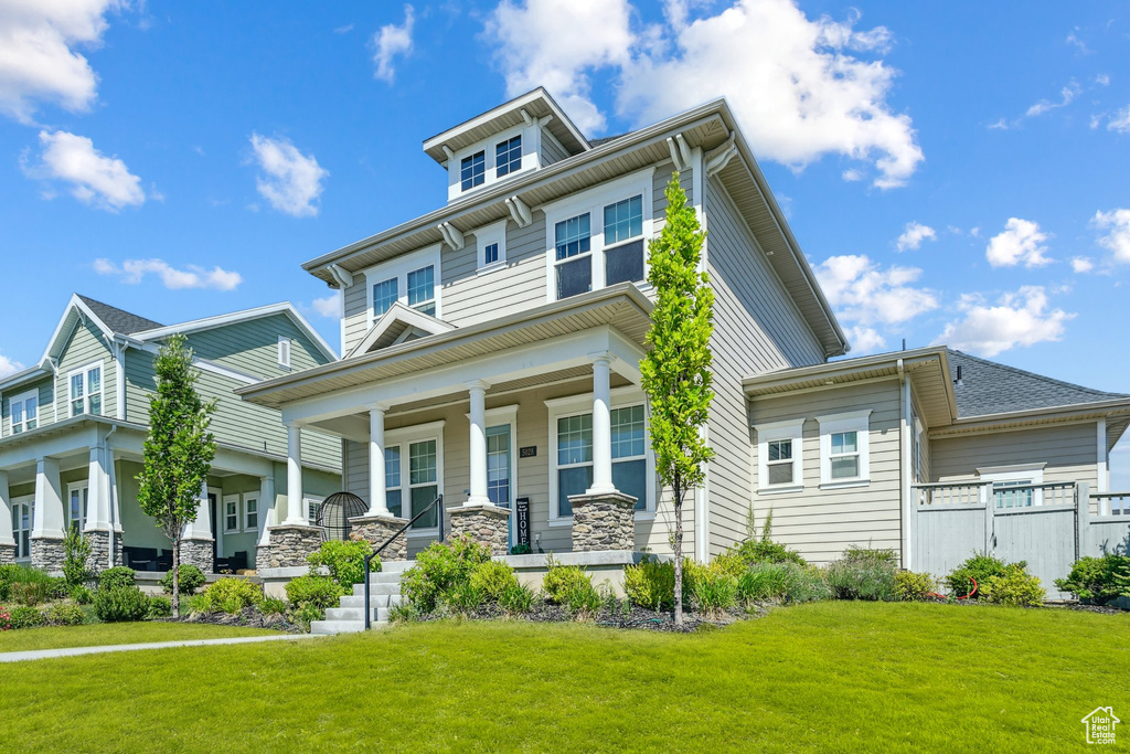 Traditional style home with covered porch and a front yard