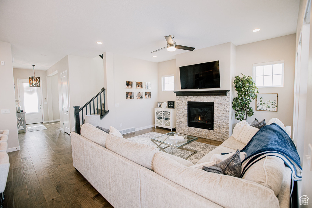 Living room with plenty of natural light, stairs, wood finished floors, ceiling fan, and recessed lighting