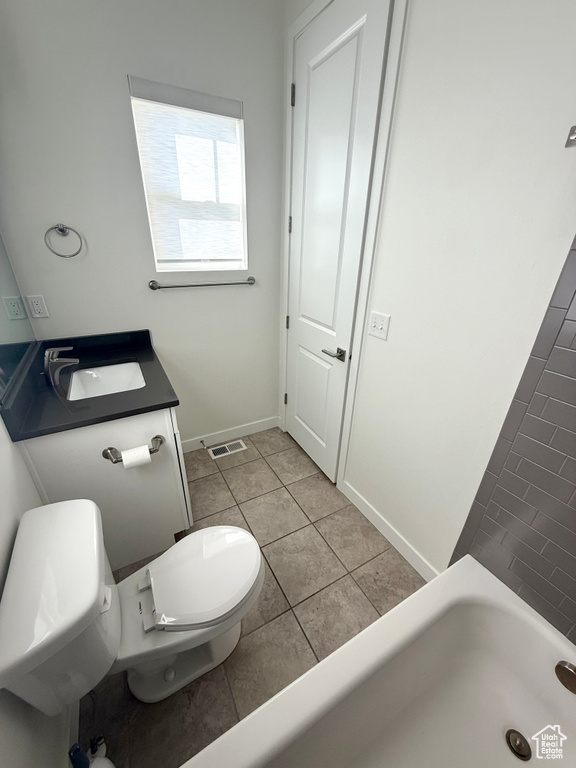 Full bath featuring toilet, tile patterned floors, baseboards, vanity, and a bath