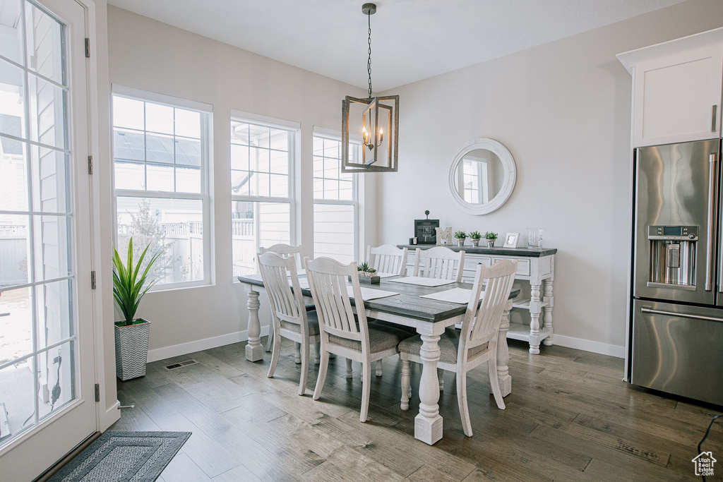 Dining room featuring a chandelier, dark wood-style floors, and baseboards