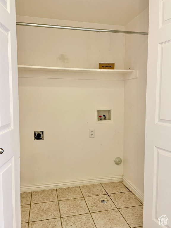 Laundry area featuring washer hookup, electric dryer hookup, light tile patterned floors, and baseboards