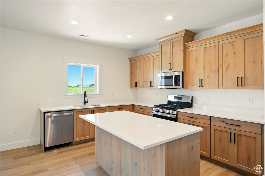 Kitchen featuring stainless steel appliances, a sink, light brown cabinets, light wood-style flooring, and recessed lighting