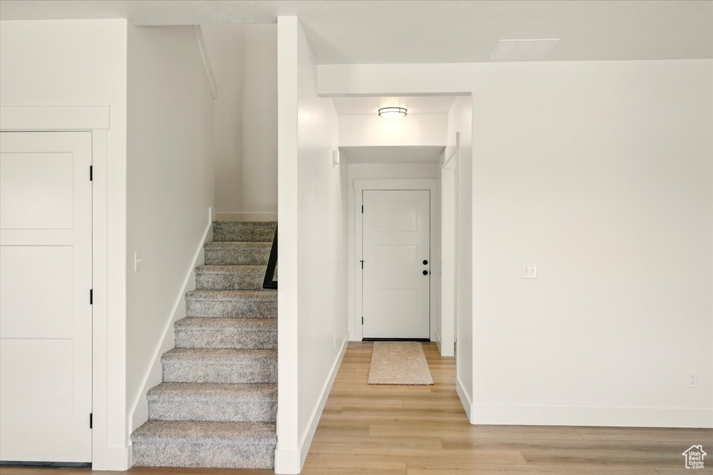 Staircase with wood finished floors and baseboards