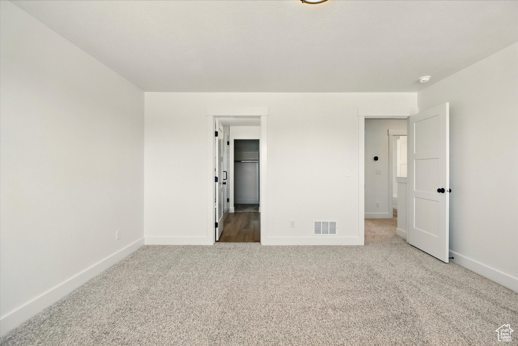 Unfurnished bedroom featuring baseboards, carpet flooring, and a spacious closet