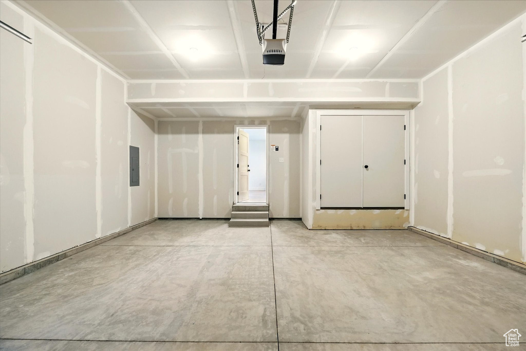 Garage featuring a garage door opener and electric panel