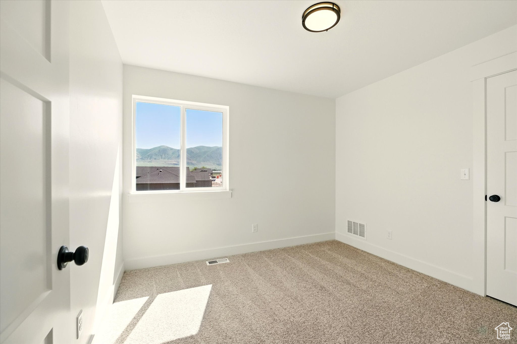 Unfurnished room featuring baseboards, carpet floors, and a mountain view