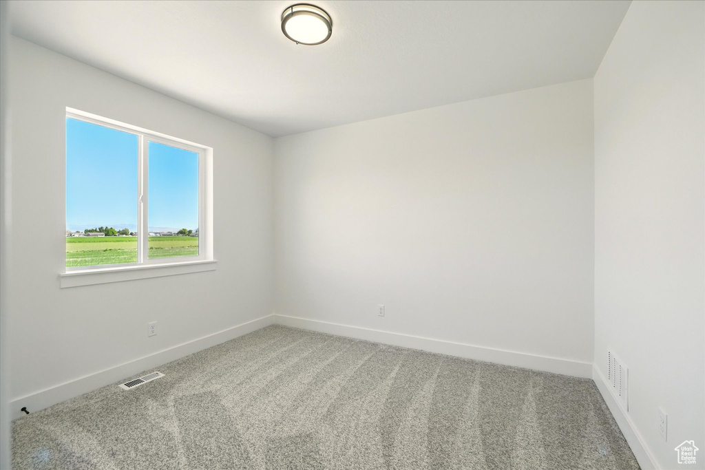 Carpeted spare room with baseboards