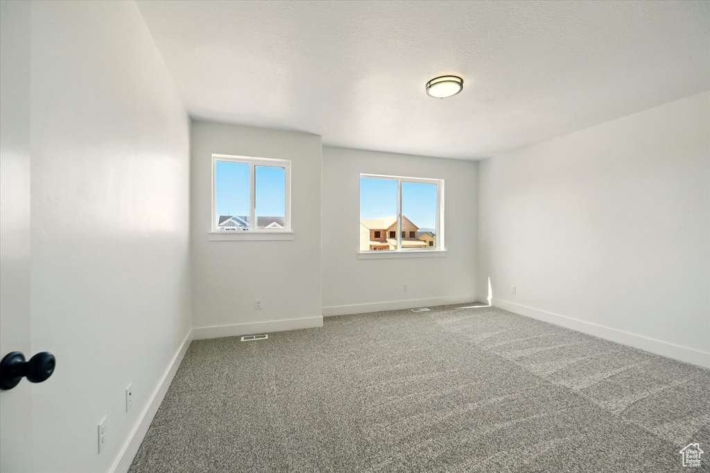 Empty room with carpet and baseboards