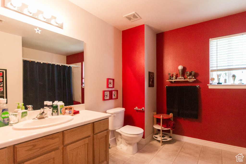Full bathroom with vanity, toilet, tile patterned flooring, baseboards, and curtained shower