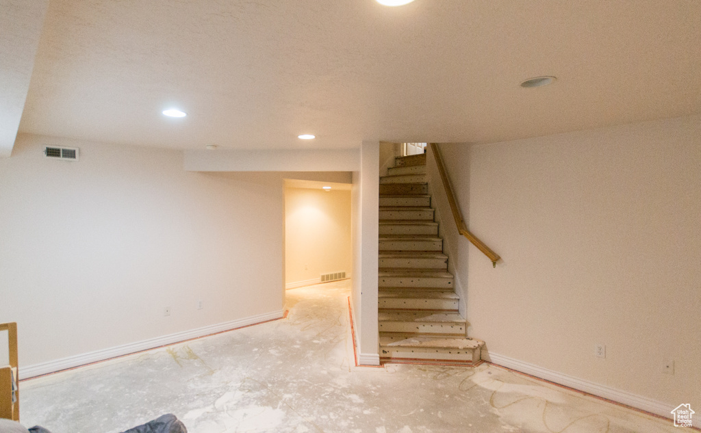 Finished basement with stairs, recessed lighting, and carpet floors