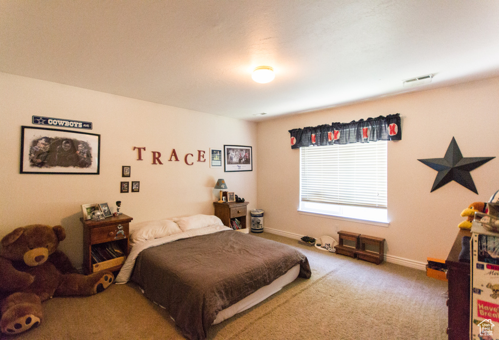 Bedroom featuring carpet and baseboards