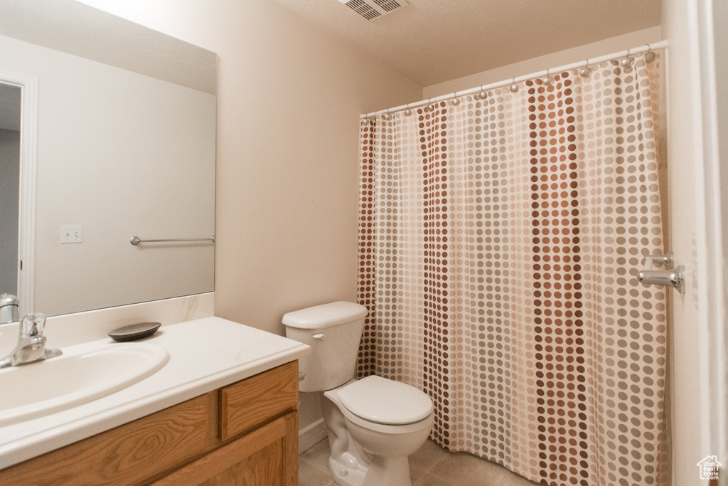 Full bathroom featuring vanity, toilet, tile patterned flooring, and a shower with shower curtain