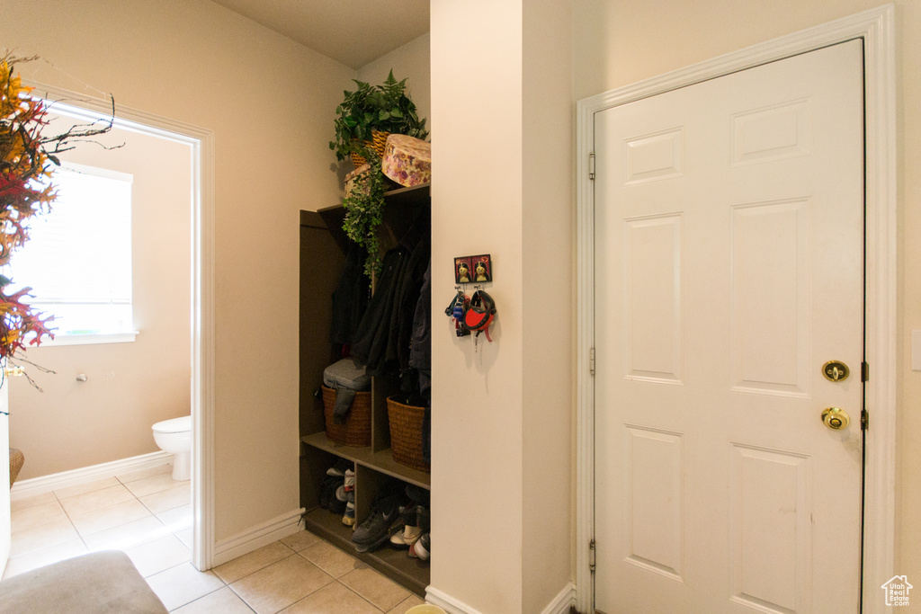 Mudroom with light tile patterned floors and baseboards