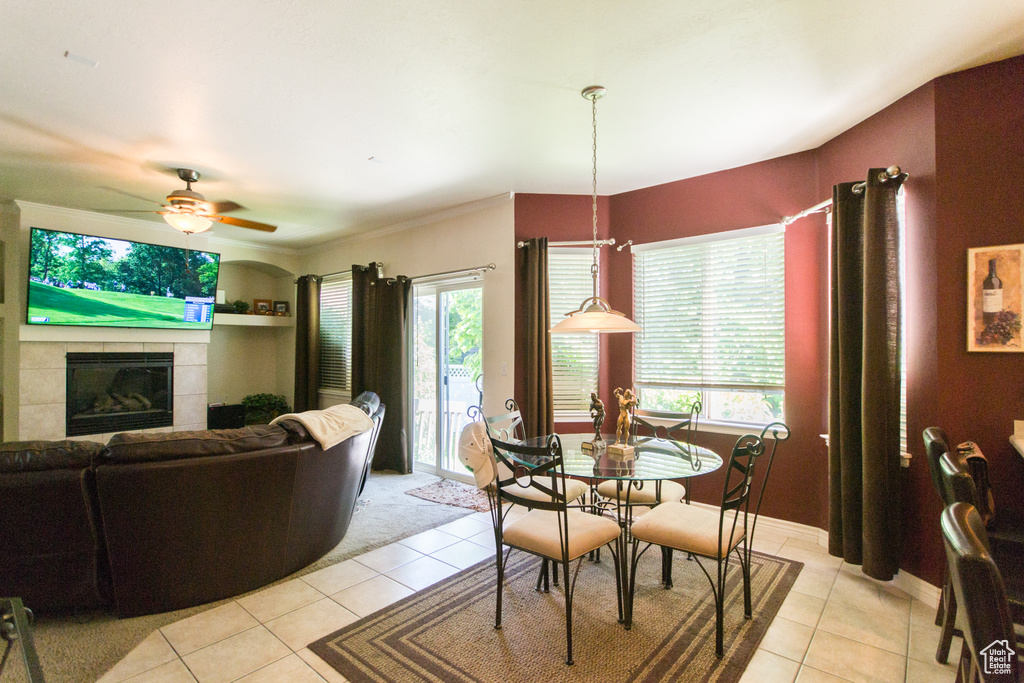 Dining space with light tile patterned floors, healthy amount of natural light, and ceiling fan