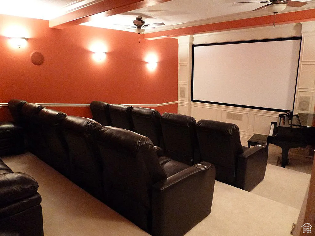 Cinema room with a ceiling fan and light carpet