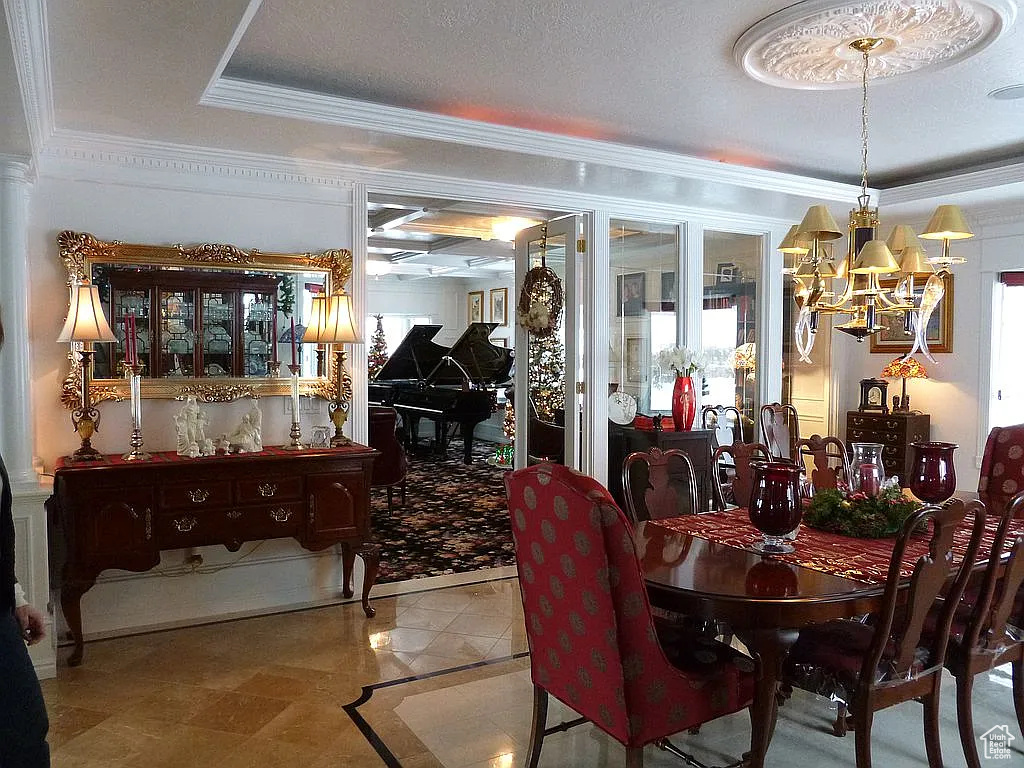 Dining space with a chandelier and crown molding