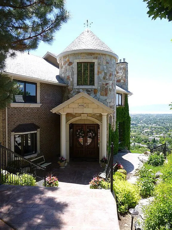 View of front of home featuring stone siding and a chimney
