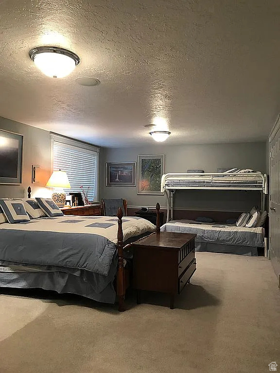 Carpeted bedroom with a textured ceiling