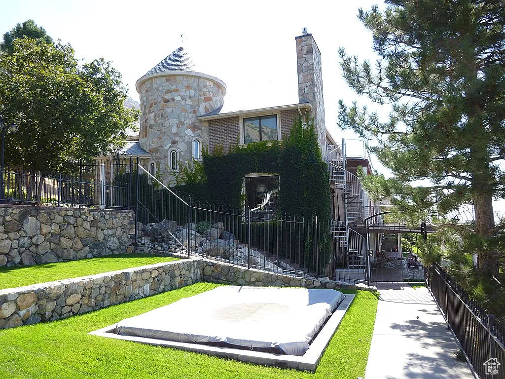 Back of house with stairway, community basketball court, and a chimney