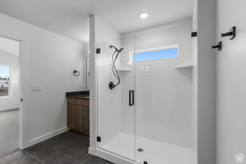 Bathroom with healthy amount of natural light, a stall shower, vanity, and baseboards