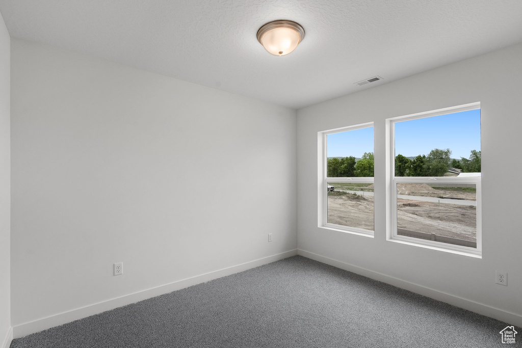 Carpeted empty room featuring baseboards