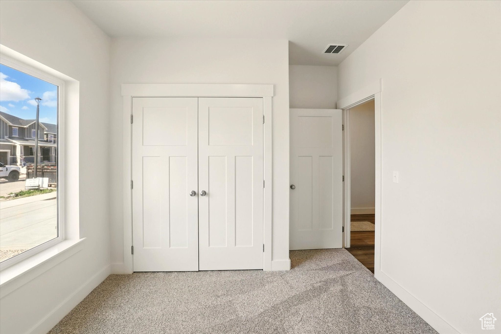 Unfurnished bedroom featuring carpet, a closet, and baseboards