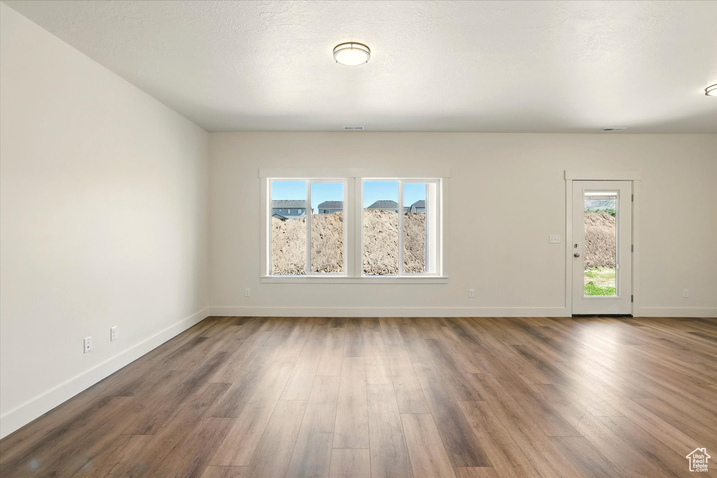 Spare room featuring wood finished floors and baseboards