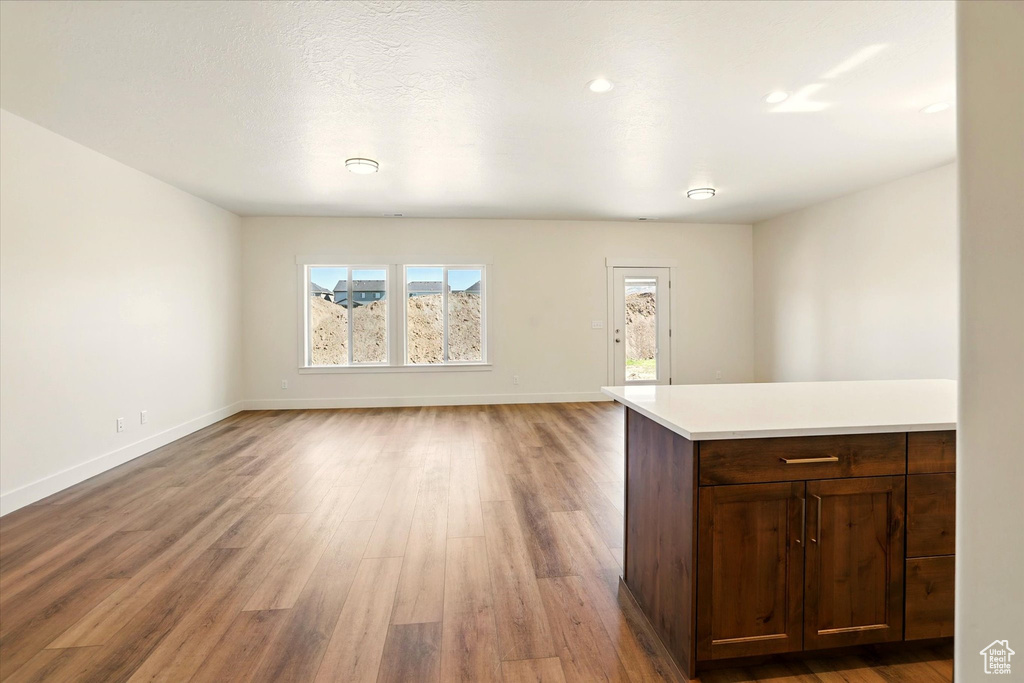 Unfurnished living room with light wood-type flooring and baseboards