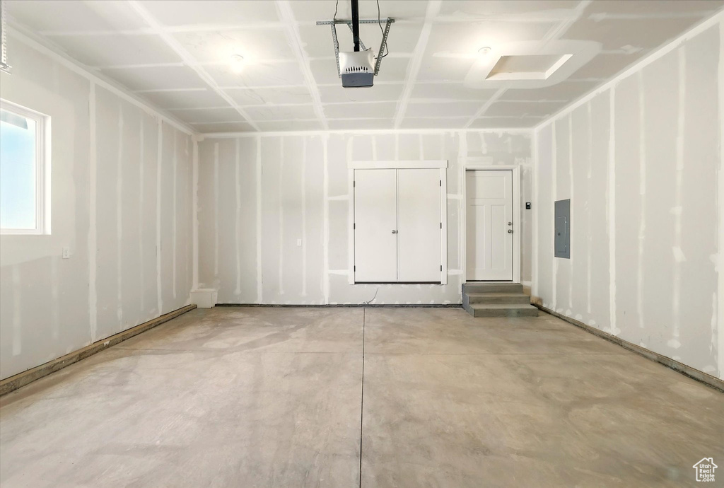 Garage featuring electric panel and a garage door opener