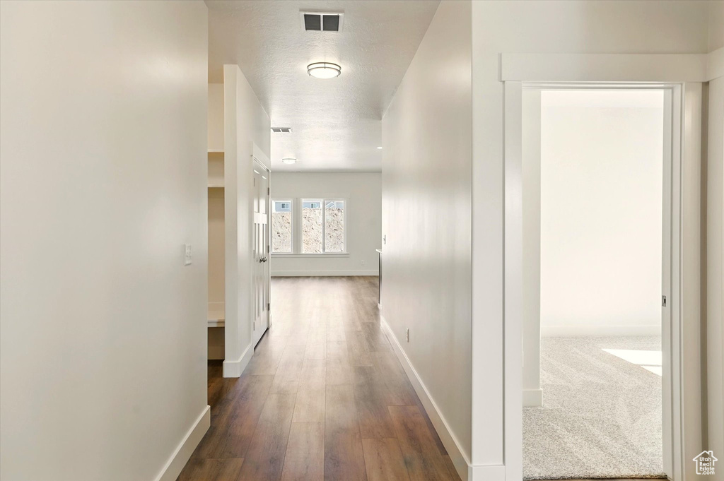 Hallway with baseboards and wood finished floors