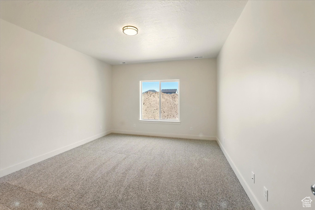 Unfurnished room with light colored carpet and baseboards