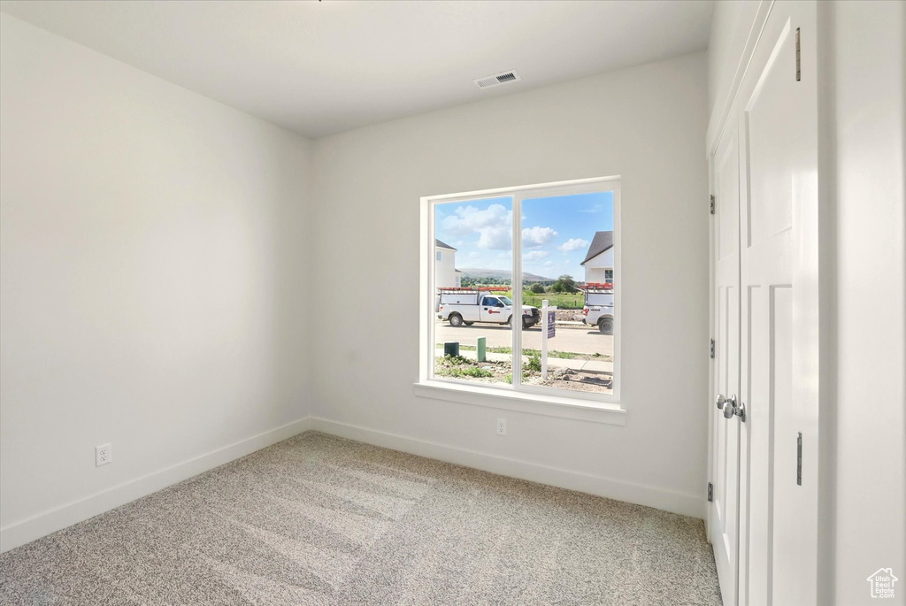Carpeted empty room featuring baseboards
