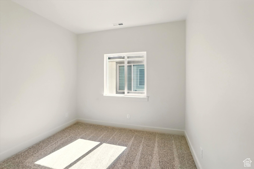 Empty room featuring carpet and baseboards