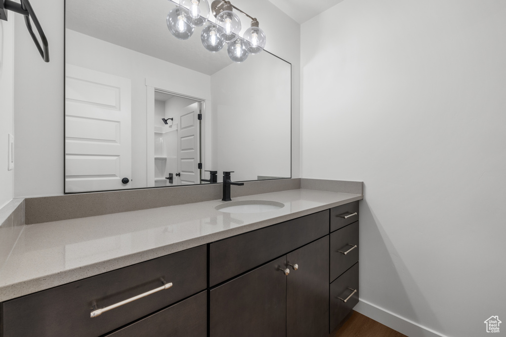 Bathroom featuring vanity, wood finished floors, and baseboards